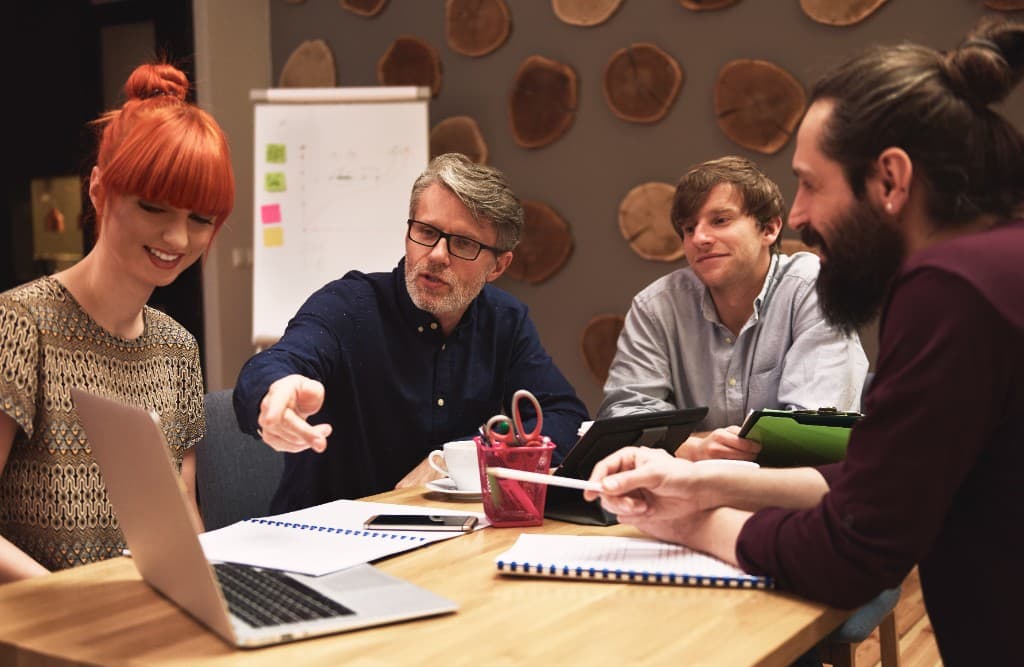 A collaborative team reviewing work together around a shared table